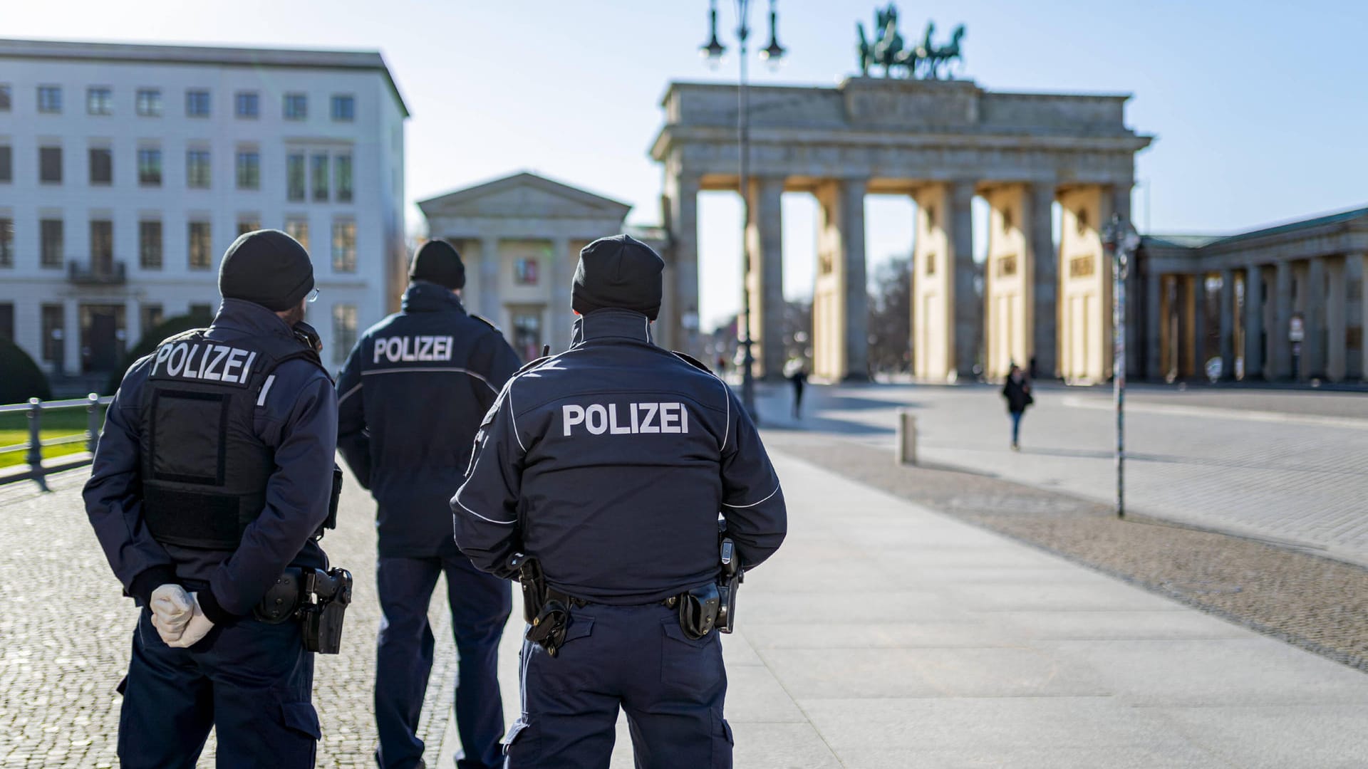 Berlin während der Ausgangsbeschränkung: Polizisten stehen auf dem sonst menschenleeren Pariser Platz am Brandenburger Tor. Berlin während der Ausgangsbeschränkung: Polizisten stehen auf dem sonst menschenleeren Pariser Platz am Brandenburger Tor.