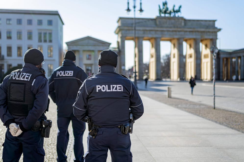 Berlin während der Ausgangsbeschränkung: Polizisten stehen auf dem sonst menschenleeren Pariser Platz am Brandenburger Tor.