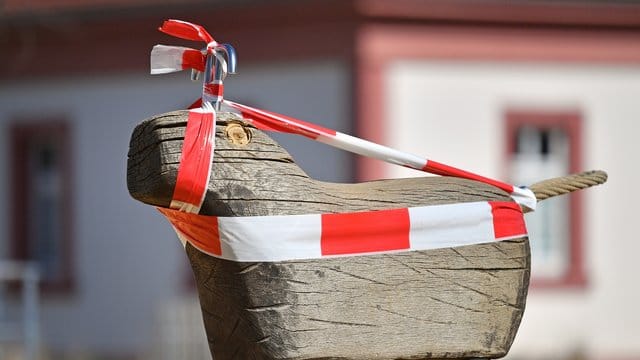 Mit rot-weißem Absperrband ist ein Spielgerät in Thüringen umwickelt, weil der Spielplatz gesperrt ist. Mit rot-weißem Absperrband ist ein Spielgerät in Thüringen umwickelt, weil der Spielplatz gesperrt ist.