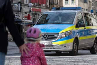 Polizisten kontrollieren in einem Streifenwagen die Corona-Maßnahmen in Dortmund: Wie lange soll das Kontaktverbot in Deutschland noch bestehen?