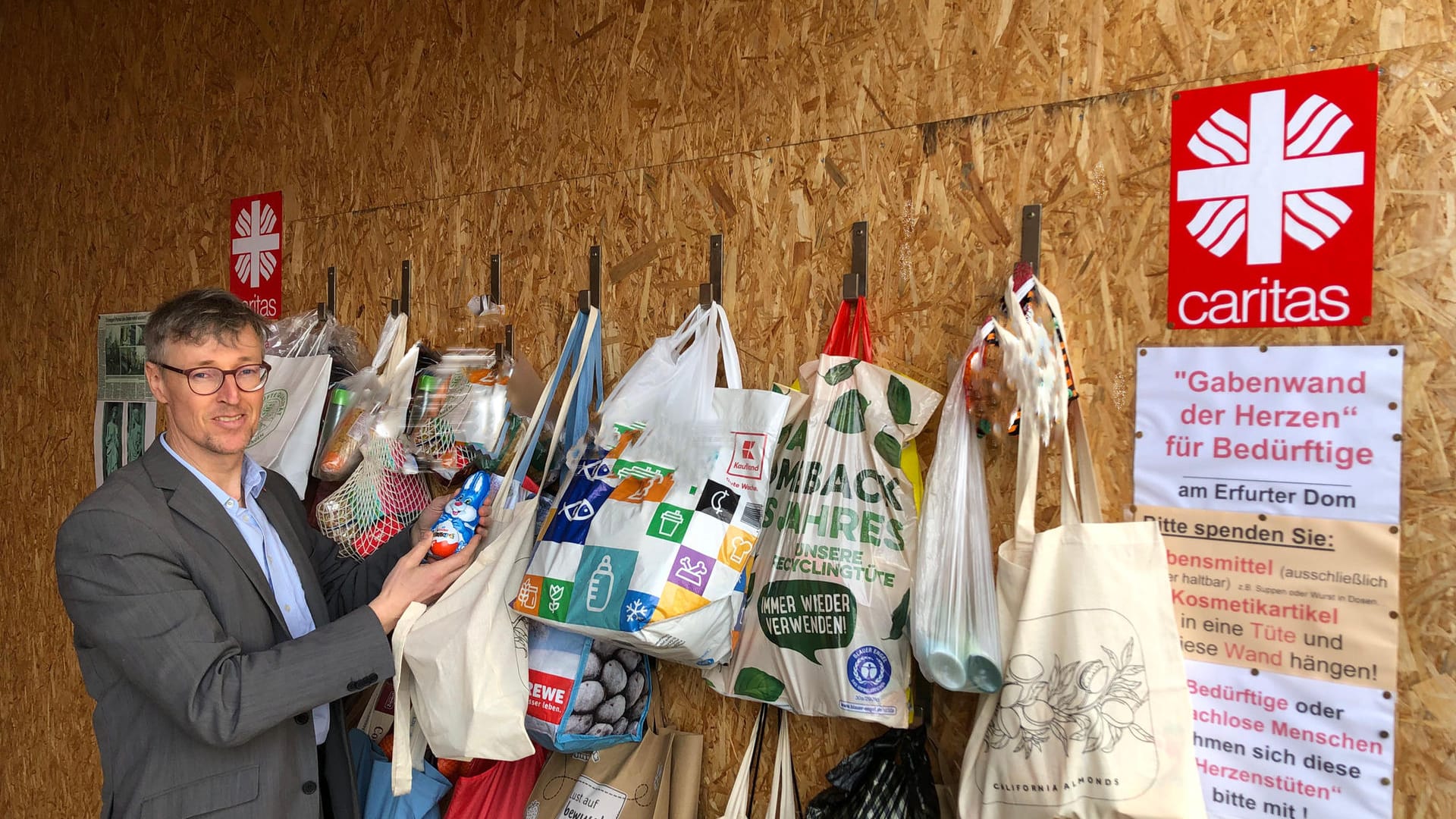 Caritas-Chef Wolfgang Langer vor der Gabenwand: Er ist beeindruckt von der Spendenbereitschaft der Erfurter.