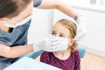 Ein Mädchen mit Gesichtsmaske beim Zahnarzt: Zahnärzte müssen in Zeiten von Corona umdenken und setzen auf Video-Behandlungen.