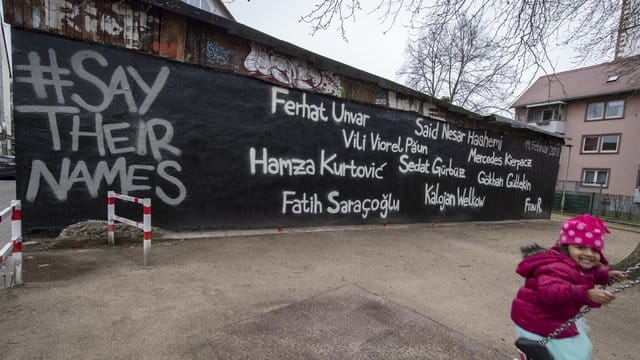 Ein kleines Mädchen schaukelt vor der Wand eines Jugendzentrums, auf dem die Namen der Opfer des Anschlags vom 19. Ein kleines Mädchen schaukelt vor der Wand eines Jugendzentrums, auf dem die Namen der Opfer des Anschlags vom 19.