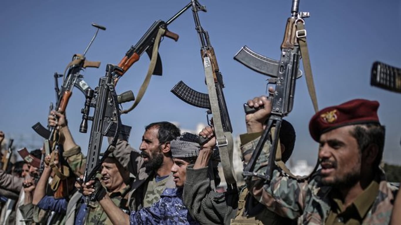 Huthi-Rebellen zeigen während einer Versammlung ihre Waffen.