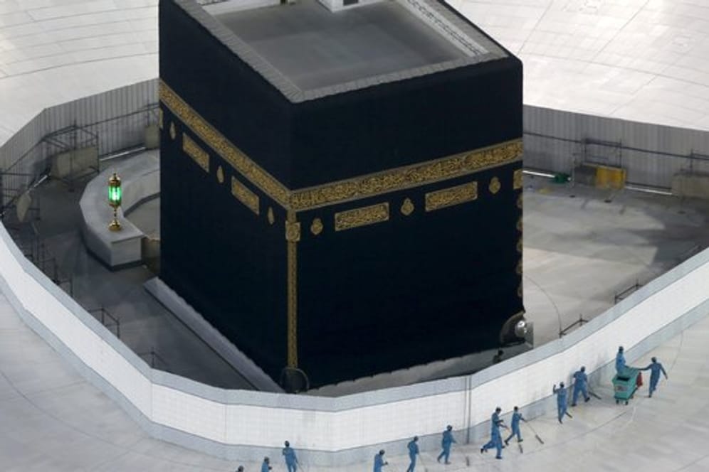 Arbeiter desinfizieren den Boden um die Kaaba, das quaderförmige Gebäude in der Großen Moschee.