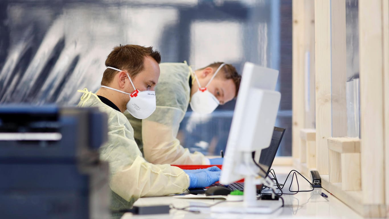 Mitarbeiter in einem Infektionsschutzzentrum in Köln: Die Zunahme bei den Neuinfektionen schwankt stark.