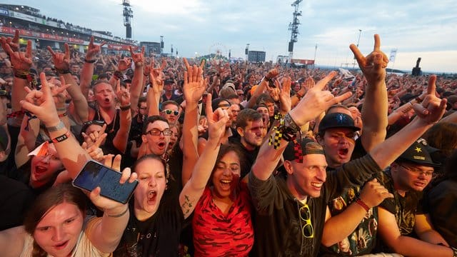 Rockfans jubeln vor der Hauptbühne des Open-Air-Festivals "Rock am Ring".