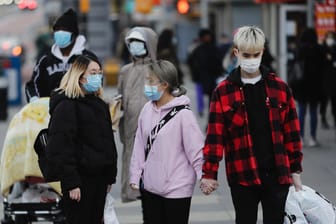 Fußgänger mit Mundschutz in New York: In keinem Land der Welt gibt es offiziell so viele registrierte Infektionen wie in den USA.