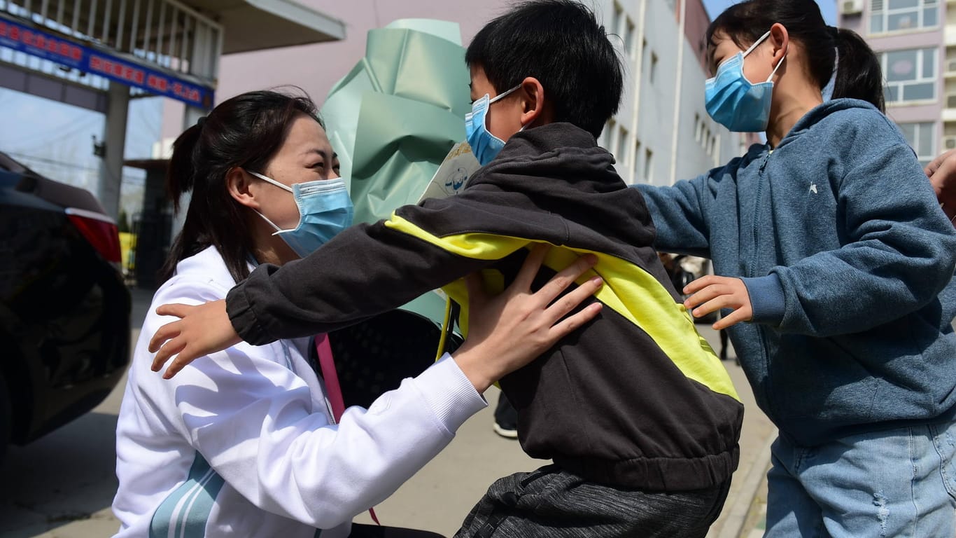 Eine Medizinerin spielt mit zwei Kindern: Aus der chinesischen Provinz Hubei gibt es momentan viele Erfolgsmeldungen – doch die Ausgangsbeschränkungen sind immer noch sehr strikt.