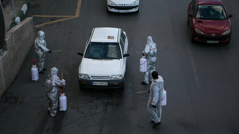Freiwillige desinfizieren ein Auto in Teheran: 70 Prozent der Wirtschaft des Landes sind mittlerweile lahmgelegt.