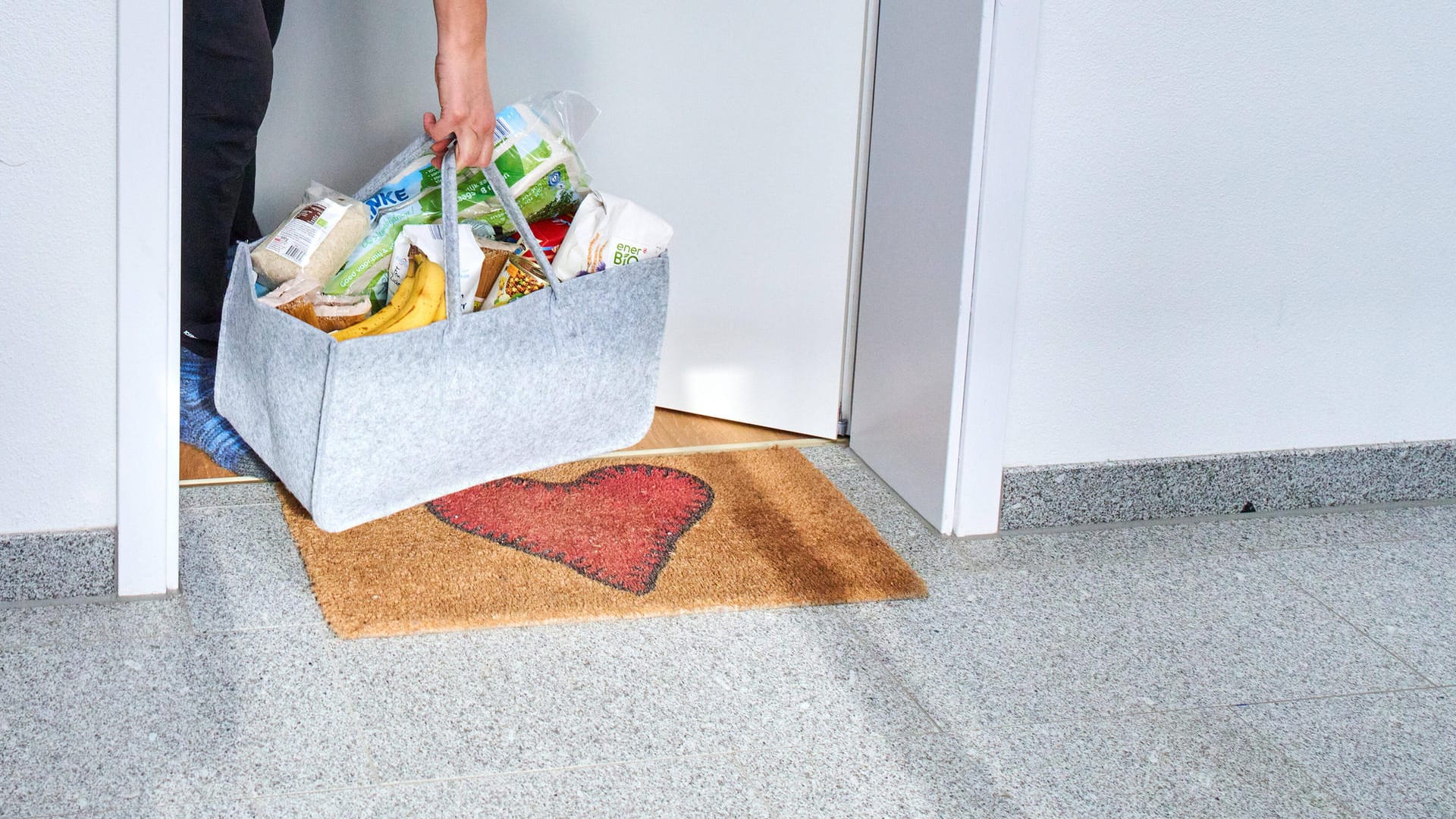 Ein Mann trägt Einkäufe durch eine Wohnungstür (Symbolbild): Um Konflikte zum Beispiel in Supermärkten zu vermeiden, bekommen Wuppertaler Ehrenamtliche in der Corona-Krise Helferausweise. Ein Mann trägt Einkäufe durch eine Wohnungstür (Symbolbild): Um Konflikte zum Beispiel in Supermärkten zu vermeiden, bekommen Wuppertaler Ehrenamtliche in der Corona-Krise Helferausweise.