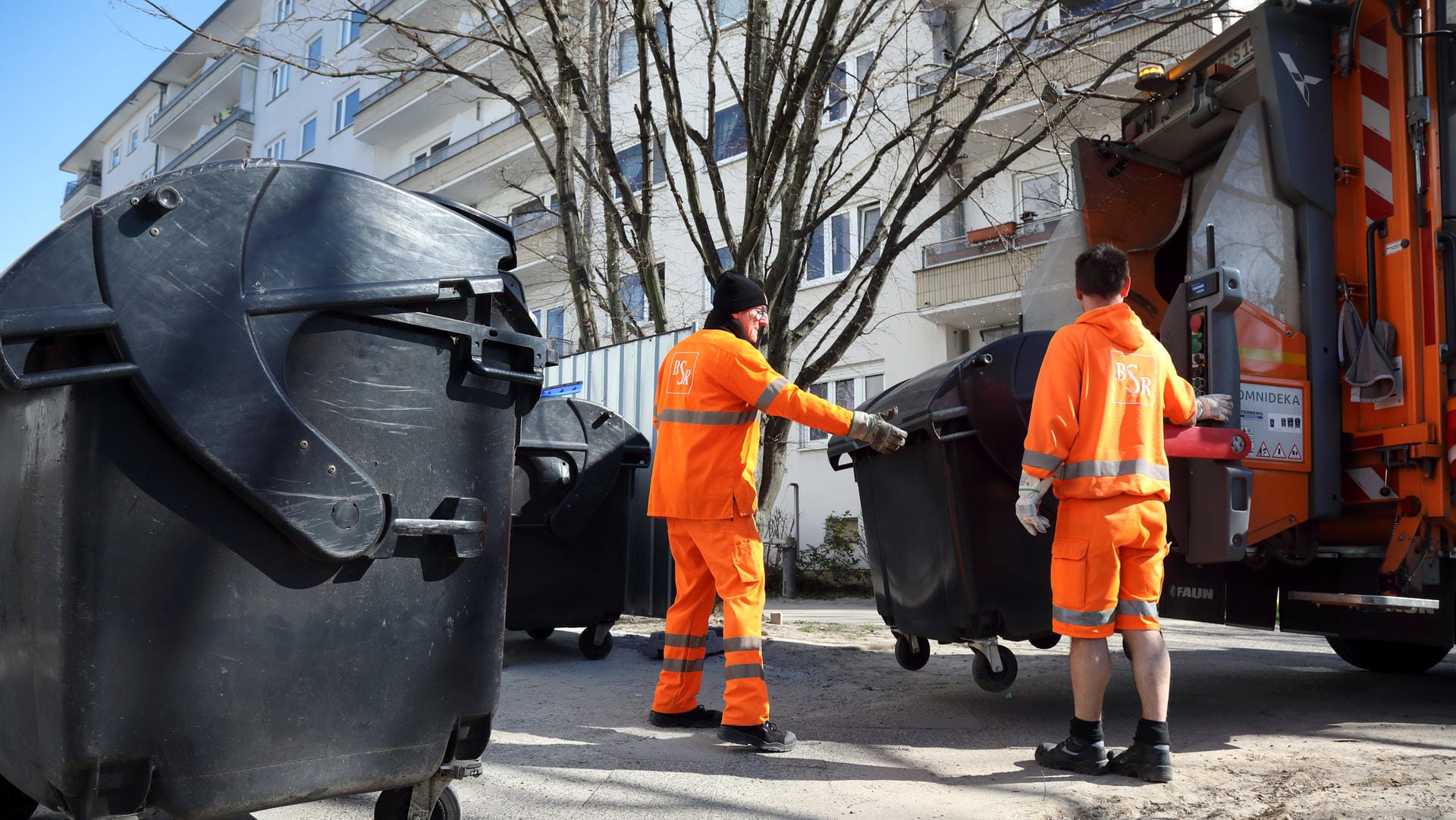 Mitarbeiter der BSR leeren volle Restmülltonnen: Die Müllabfuhr ist nun wegen der Corona-Krise teilweise etwas früher unterwegs, um Menschenansammlungen zu vermeiden.