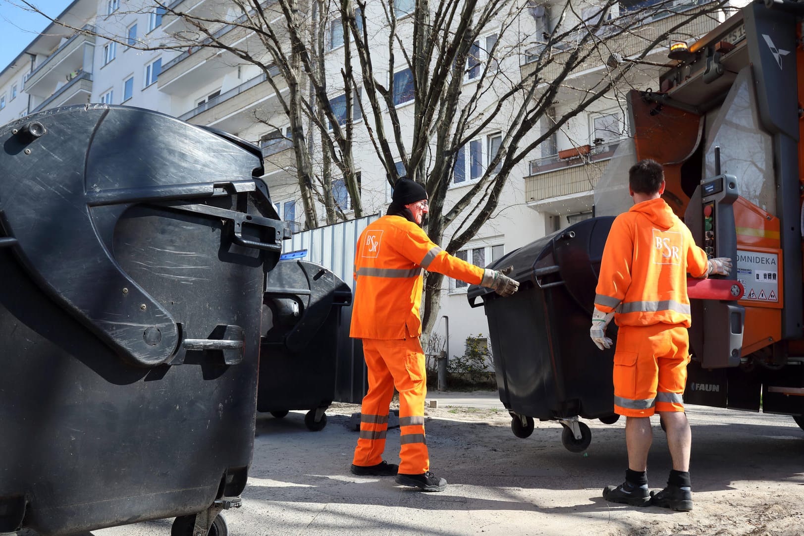 Mitarbeiter der BSR leeren volle Restmülltonnen: Die Müllabfuhr ist nun wegen der Corona-Krise teilweise etwas früher unterwegs, um Menschenansammlungen zu vermeiden.