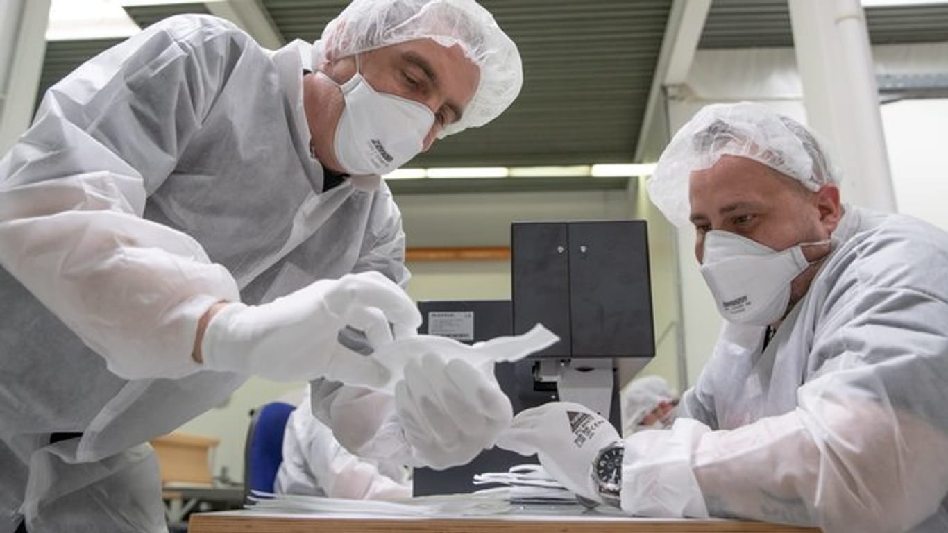 Mitarbeiter der Zender Germany GmbH fertigen Schutzmasken an.