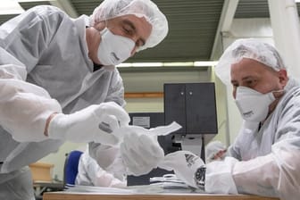 Mitarbeiter der Zender Germany GmbH fertigen Schutzmasken an.