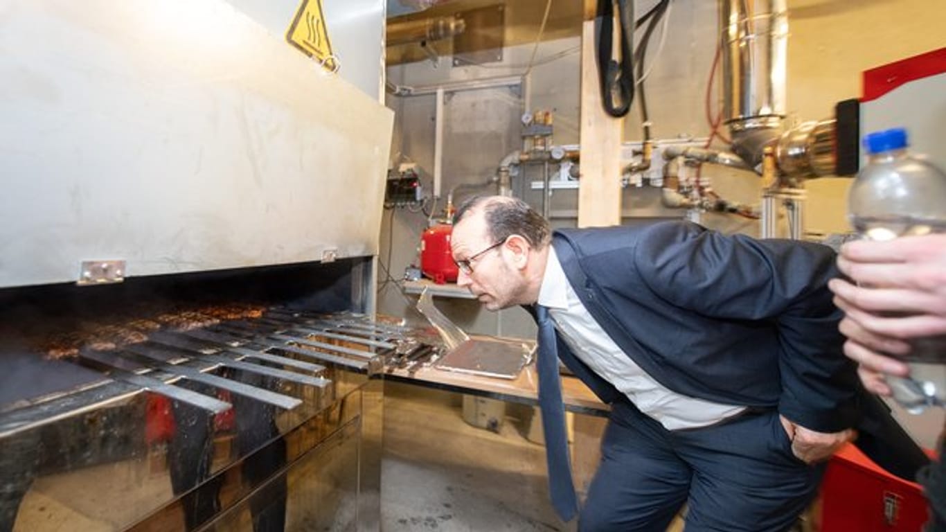 Mohammad Aleysa, Gruppenleitung Verbrennungs- und Umweltschutztechnik am Fraunhofer-Institut für Bauphysik IBP, schaut in einem Labor des IBP in einen Grill.