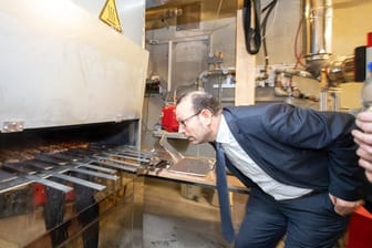 Mohammad Aleysa, Gruppenleitung Verbrennungs- und Umweltschutztechnik am Fraunhofer-Institut für Bauphysik IBP, schaut in einem Labor des IBP in einen Grill.