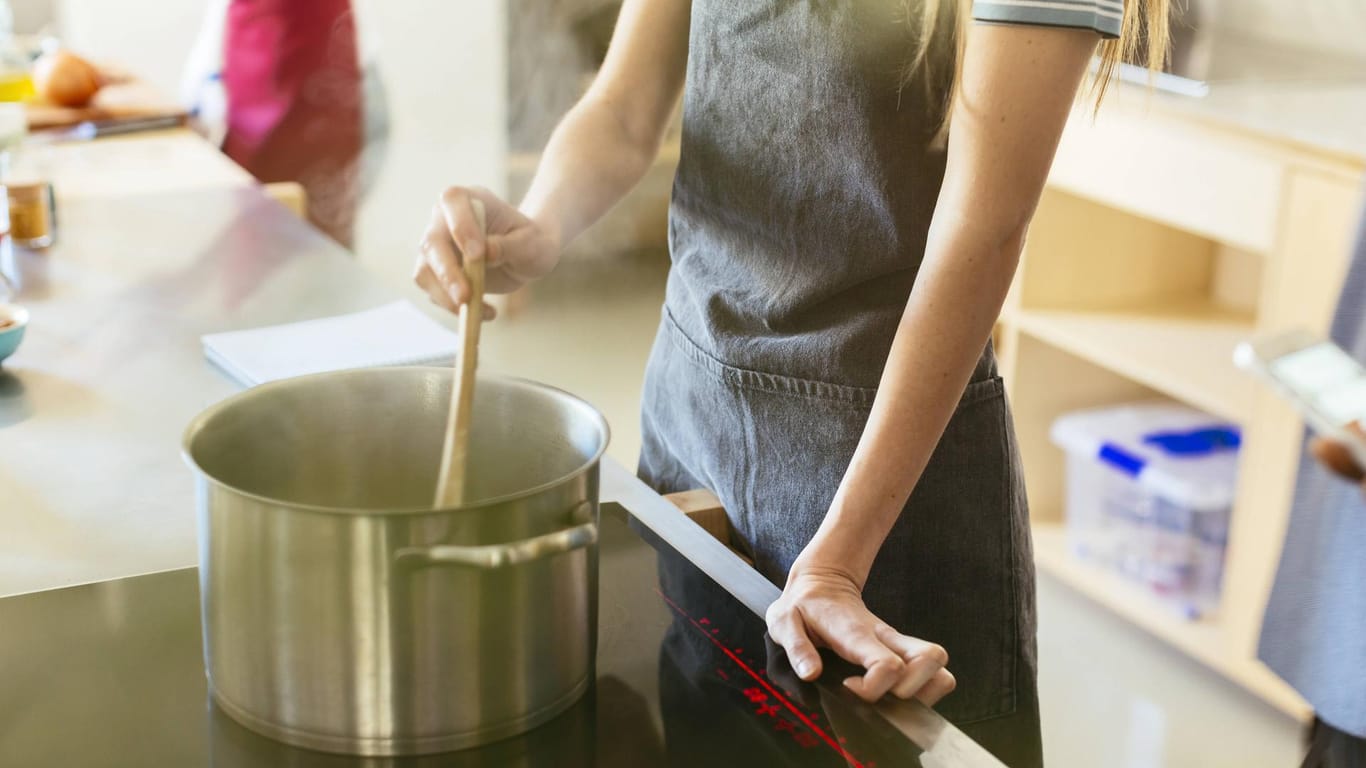 Eine Frau rührt in einem Kochtopf (Symbolbild): In Mainz kochen Gastronomen für Menschen, die in systemrelevanten Berufen arbeiten.