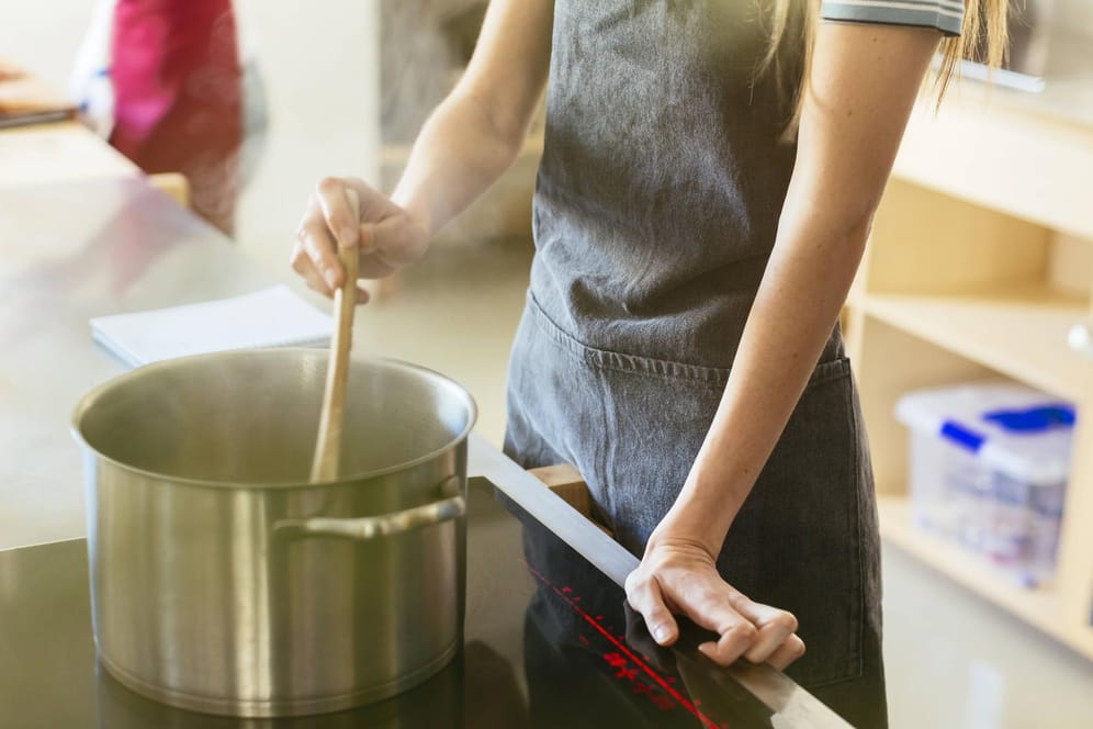 Eine Frau rührt in einem Kochtopf (Symbolbild): In Mainz kochen Gastronomen für Menschen, die in systemrelevanten Berufen arbeiten.