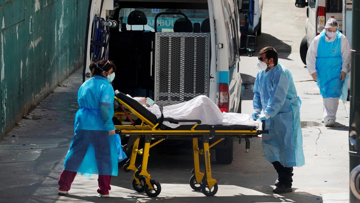 Rettungssanitäter bringen einen Covid-19-Patienten in ein Pflegeheim in Leganes bei Madrid.
