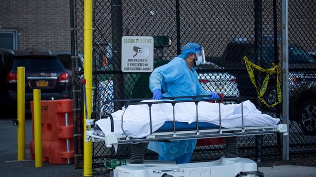 Ein medizinischer Mitarbeiter überführt den Leichnam eines Coronavirus-Opfers in New York. Ein medizinischer Mitarbeiter überführt den Leichnam eines Coronavirus-Opfers in New York.