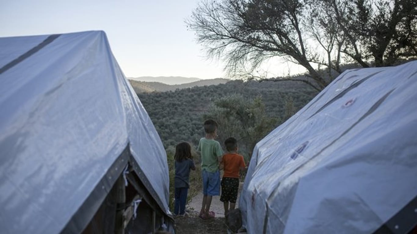 Kinder stehen zwischen Zelten in einem provisorischen Flüchtlingslager auf Lesbos.