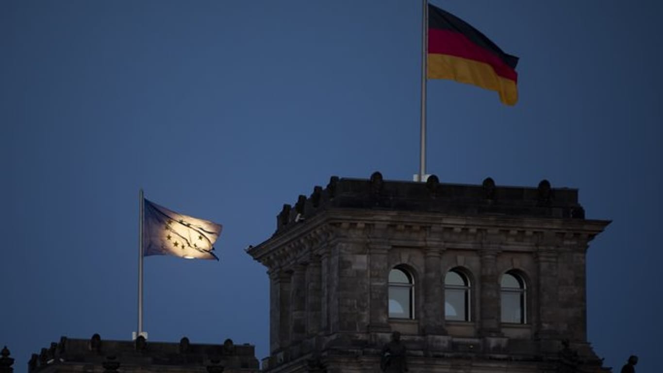 Der Mond geht hinter der EU-Flagge auf dem Reichstagsgebäude in Berlin auf.