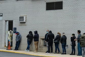 Menschen stehen vor einem Coronavirus-Testzentrum in New York Schlange.