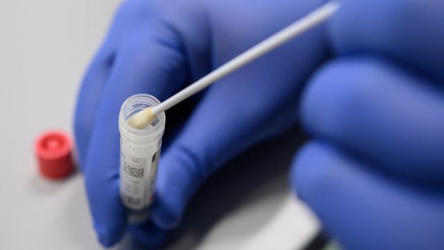 Ein Mann zeigt einen Abstrich für das Testverfahren auf das Virus SARS-CoV-2 (Symbolbild): Die Zahl der Infektionen steigt weiter. Ein Mann zeigt einen Abstrich für das Testverfahren auf das Virus SARS-CoV-2 (Symbolbild): Die Zahl der Infektionen steigt weiter.