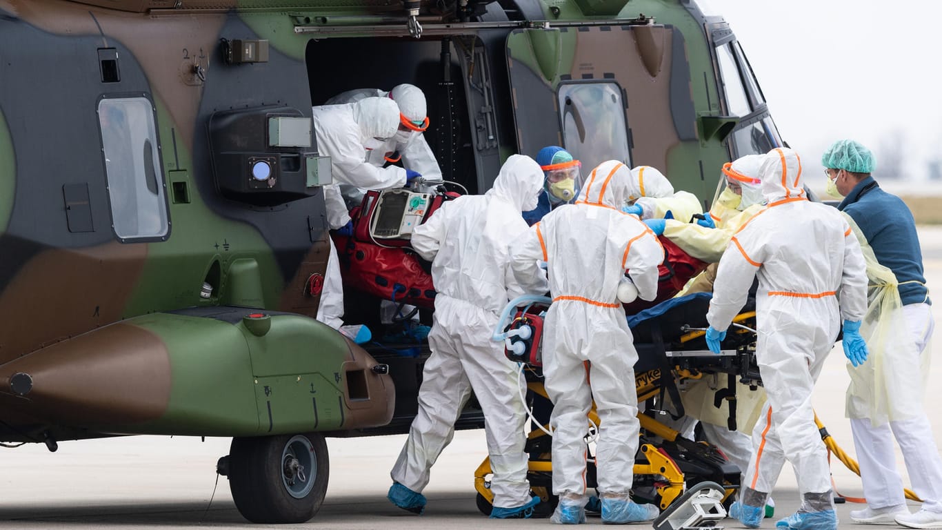 Ein schwer an Covid-19 erkrankter Patient aus Frankreich wird auf dem Flughafen Dresden aus einem Nato-Helikopter getragen.