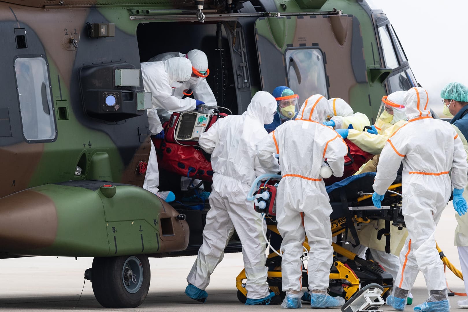 Ein schwer an Covid-19 erkrankter Patient aus Frankreich wird auf dem Flughafen Dresden aus einem Nato-Helikopter getragen.