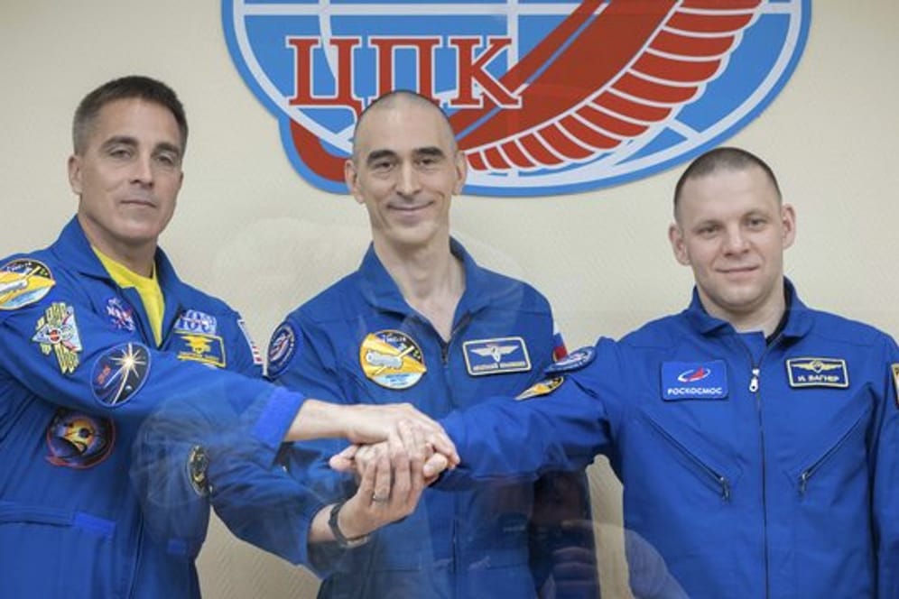 Nasa-Astronaut Christopher Cassidy (l) und die russischen Kosmonauten Anatoli Iwanischin (M) und Iwan Wagner bei einer Pressekonferenz im Weltraumbahnhof Baikonur hinter Schutzglas.
