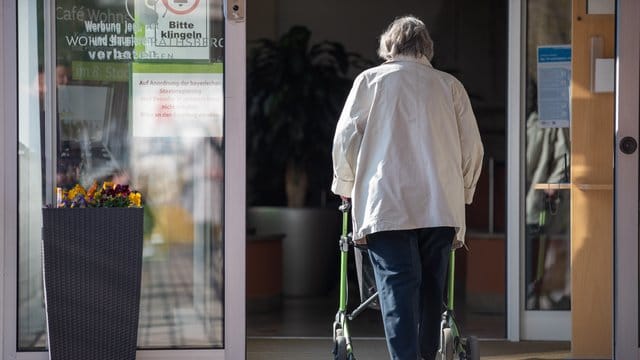 Eine Seniorin betritt mit ihrer Gehhilfe den Eingang eines Senioren-Wohnstifts. Eine Seniorin betritt mit ihrer Gehhilfe den Eingang eines Senioren-Wohnstifts.