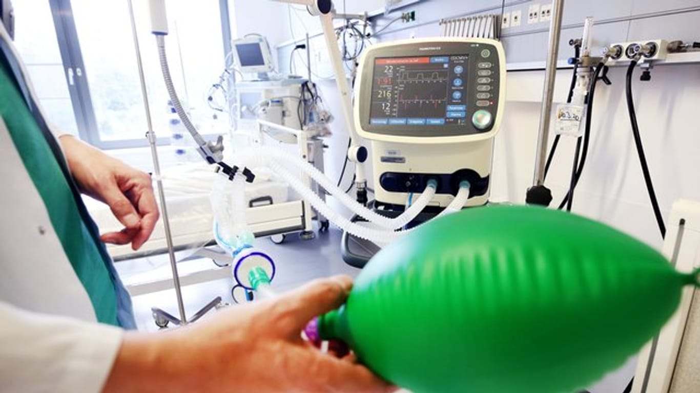 An einem Intensivbett für Corona-Patienten zeigt ein Arzt, die Funktionsweise eines Beatmungsgerätes.