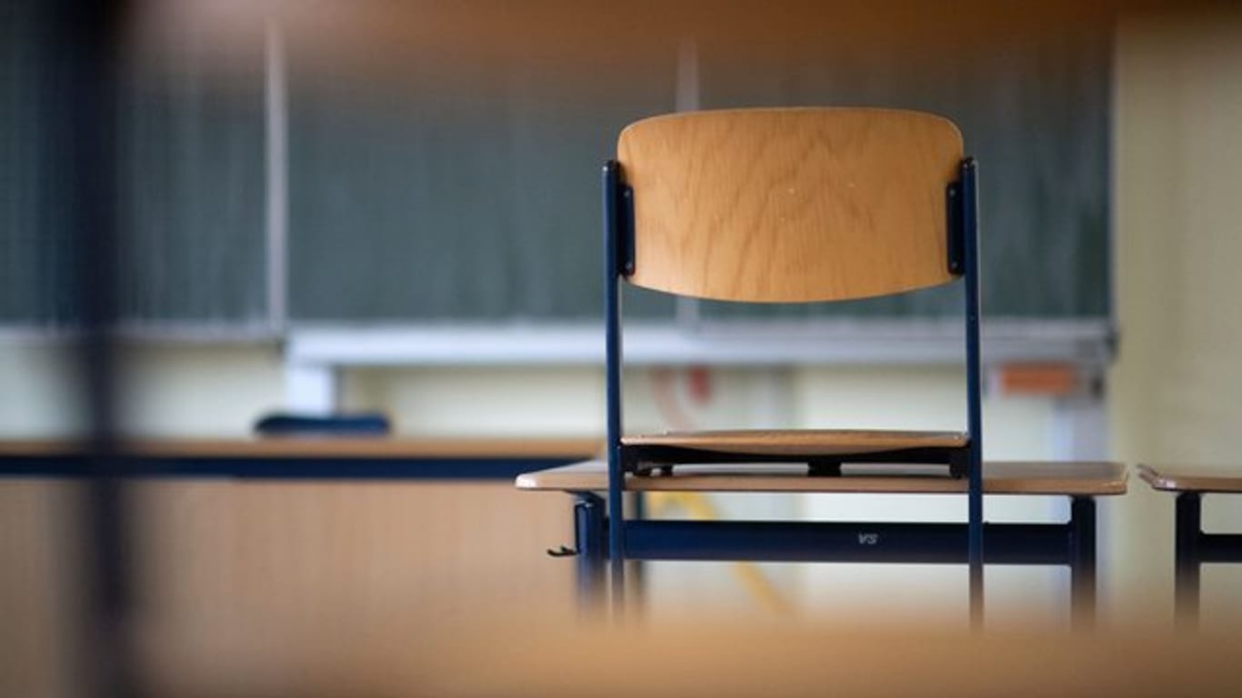 Im leeren Klassenzimmer einer Realschule steht ein Stuhl auf dem Tisch.