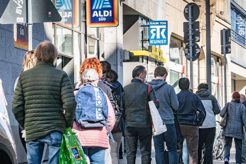 In einer langen Schlange warten Menschen auf Einlass zum Tätigen letzter Ostereinkäufe in Frankfurt.