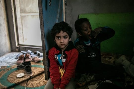 Vertriebene Kinder sitzen in einem Zimmer in Tripolis.