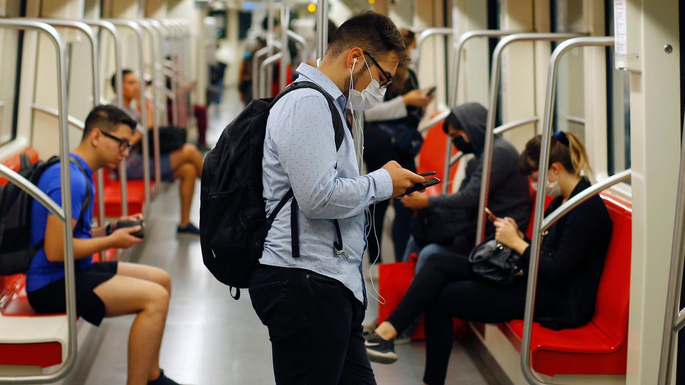 Ein Mann informiert sich in der U-Bahn auf dem Smartphone: Im Internet gibt es zum Coronavirus derzeit besonders viele Fake News und Verschwörungstheorien.