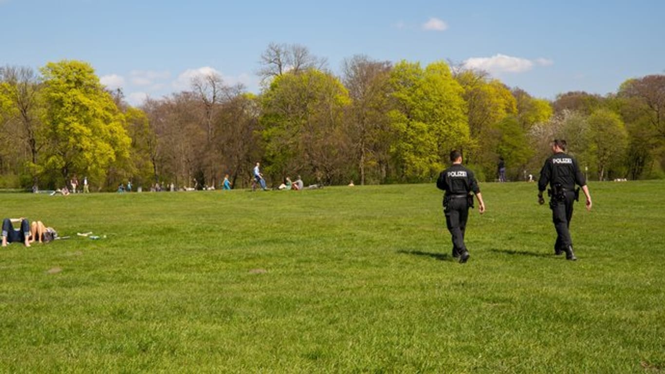 Zwei Polizisten gehen durch den Englischen Garten in München.