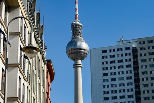 Der Fernsehturm ist zwischen sanierten Altbauten und einem Plattenbau-Hochhaus in Berlin zu sehen.