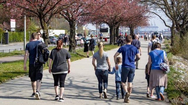 Osterausflügler gehen bei strahlendem Sonnenschein an der Elbe entlang. Osterausflügler gehen bei strahlendem Sonnenschein an der Elbe entlang.