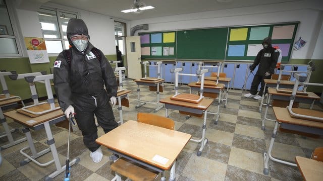 Soldaten in Schutzanzügen versprühen Desinfektionsmittel in einem Klassenzimmer der Gyeongu-Mittelschule, um der Ausbreitung des neuartigen Coronavirus entgegenzuwirken. Soldaten in Schutzanzügen versprühen Desinfektionsmittel in einem Klassenzimmer der Gyeongu-Mittelschule, um der Ausbreitung des neuartigen Coronavirus entgegenzuwirken.