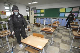Soldaten in Schutzanzügen versprühen Desinfektionsmittel in einem Klassenzimmer der Gyeongu-Mittelschule, um der Ausbreitung des neuartigen Coronavirus entgegenzuwirken.