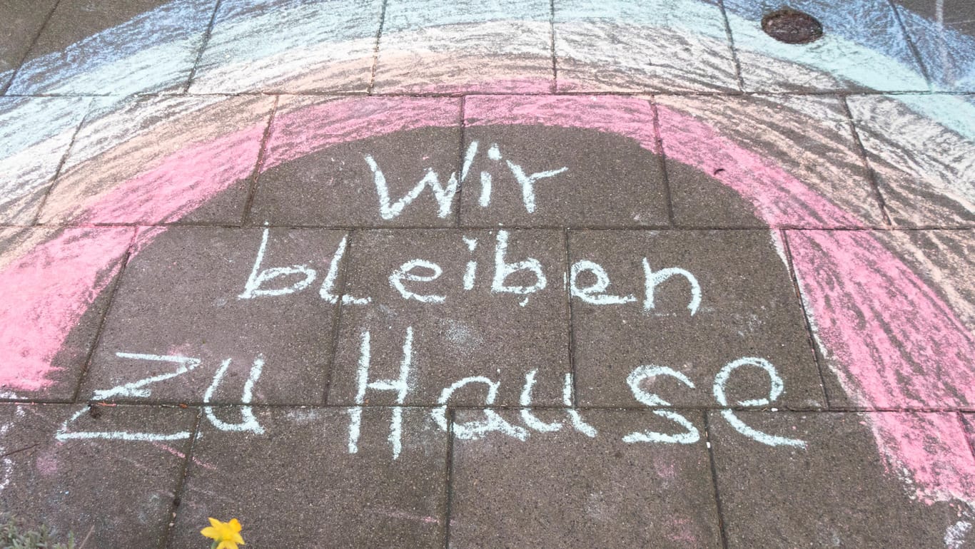 "Wir bleiben zu Hause" steht mit Kreide vor einem Haus in Bielefeld: In der Stadt sind die Corona-Fälle weniger stark gestiegen, als zuvor.