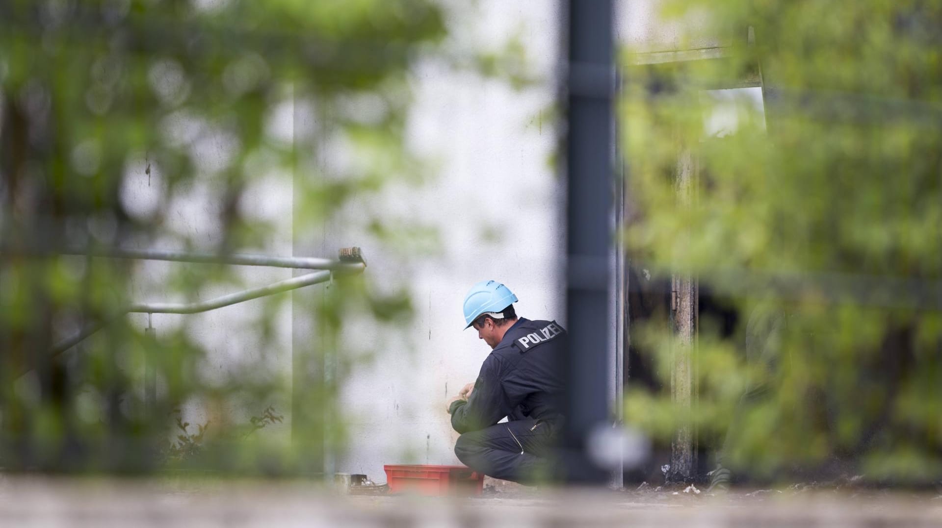 Ein Polizeibeamter bei der Spurensicherung an einem Brandort (Symbolfoto). Nach einem Anschlag auf Strom- und Internetkabel in Berlin ermitteln Experten des LKA (Symbolfoto).