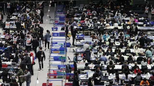 Mitglieder der Nationalen Wahlkommission zählen in einer Sporthalle in Seoul Stimmzettel aus. Mitglieder der Nationalen Wahlkommission zählen in einer Sporthalle in Seoul Stimmzettel aus.