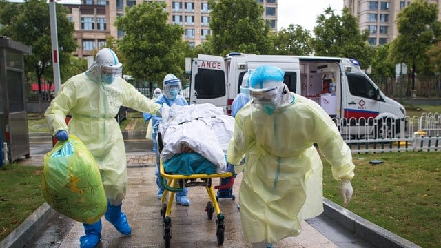 Medizinisches Personal in Wuhan rollt einen Patienten auf einer Liege in das Tongji-Krankenhauses.