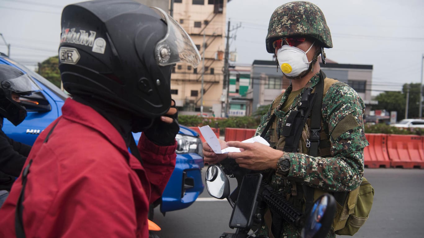 Ein Militär kontrolliert in der philippinischen Hauptstadt Manila einen Motorradfahrer: Die Regierungschefs in Südostasien bauen in der Corona-Krise ihre Macht aus.