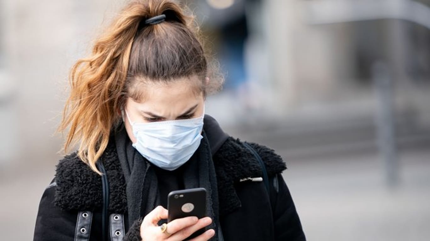 Eine Frau mit Mundschutz: Die Bundesregierung setzt große Hoffnungen in eine App zur Nachverfolgung von Corona-Infektionsketten, die aktuell in Berlin getestet wird.