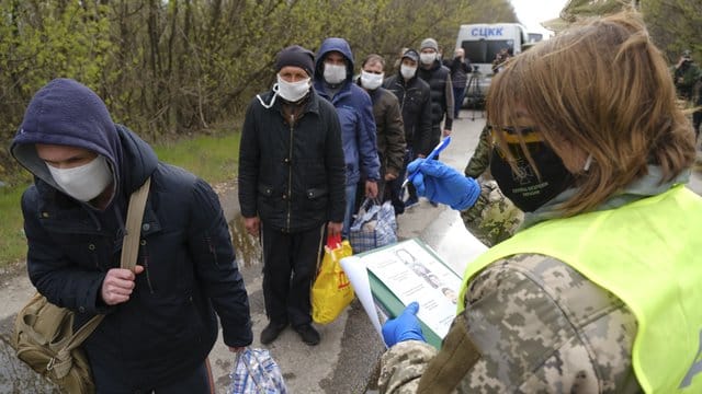 Gefangene mit Mundschutz werden registriert. Gefangene mit Mundschutz werden registriert.